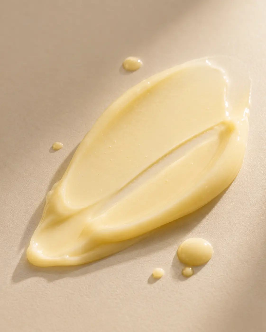 Close-up macro texture of Gold Plus Luxury Keratin cream showing its soft creamy yellow formula